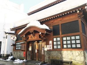 un edificio con la neve sopra di esso di Asagama House a Nozawa Onsen
