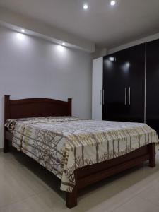 1 dormitorio con 1 cama y armario negro en Apartamento frente al Aeropuerto de Maiquetía, en Maiquetía