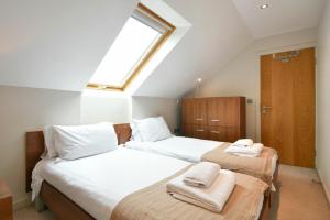 a attic bedroom with two beds with towels on them at Links Barn in Seahouses