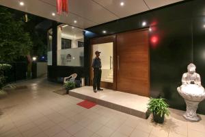 a man standing in front of a building at Hotel Mumbai House Ghansoli, Navi Mumbai in Navi Mumbai