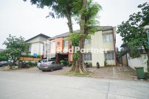 a tree in a parking lot in front of a building at Tirta Mansion Lippo Karawaci Mitra RedDoorz in Karawaci