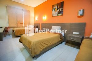 Postel nebo postele na pokoji v ubytování Tirta Mansion Lippo Karawaci Mitra RedDoorz