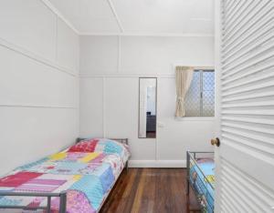 1 dormitorio con cama, espejo y ventana en Relax on Rickman, en Woorim