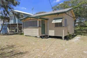 a tiny house with a green door in a yard at Relax on Rickman in Woorim