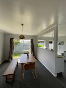 a room with a table and a bench and a window at Green Door - One bedroom apartment in Whakatane