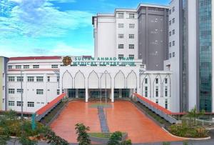 a large white building with a red courtyard in front of it at UIA Younee Kuantan Homestay 3R2B 9pax 5 min to town in Kuantan