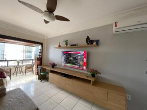 sala de estar con TV de pantalla plana en la pared en Apartamento Maravilhoso, en Capão da Canoa