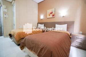 Postel nebo postele na pokoji v ubytování Tirta Mansion Lippo Karawaci Mitra RedDoorz