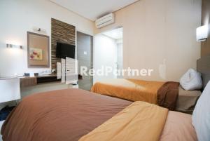 Postel nebo postele na pokoji v ubytování Tirta Mansion Lippo Karawaci Mitra RedDoorz