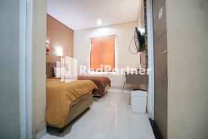 Postel nebo postele na pokoji v ubytování Tirta Mansion Lippo Karawaci Mitra RedDoorz