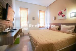 Postel nebo postele na pokoji v ubytování Tirta Mansion Lippo Karawaci Mitra RedDoorz