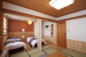 een slaapkamer met 2 bedden in een kamer bij Koguma no ie in Nozawa Onsen