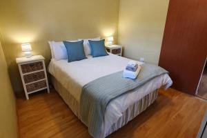 1 dormitorio con 1 cama grande con almohadas azules en Jakaranda Cabin - Self Catering Apartment, en Secunda