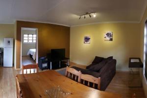 a living room with a couch and a table at Jakaranda Cabin - Self Catering Apartment in Secunda