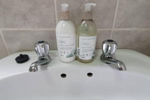 two bottles of soap sitting on top of a sink at Jakaranda Cabin - Self Catering Apartment in Secunda +38 photos