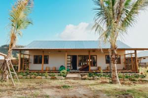 uma casa com palmeiras em frente em Happy home em Huu