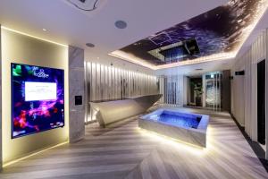 a hotel lobby with a hot tub and a tv at Hotel Cocoon -Urban Luxury- 