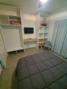 Una sala de estar con un escritorio y un televisor. en Edificio CALA, en San Bernardo