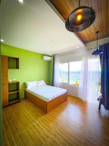 a bedroom with a bed and a large window at Anilao Ocean View Guest House in Mabini