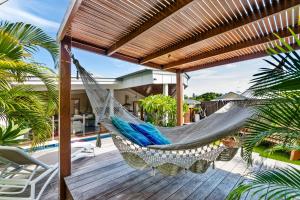 a hammock on the deck of a house at Relaxed Luxury In Paradise - A touch of Breeze! in Sunrise Beach