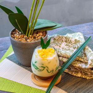 une boisson sur une table avec des baguettes et une plante dans l'établissement POP! Hotel Banjarmasin, à Banjarmasin