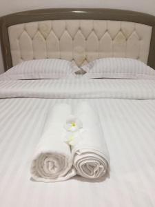 two towels on a bed with two flowers on it at Hotel My New Lovina in Lovina