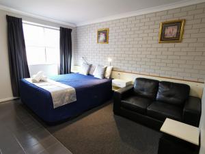 Habitación de hotel con cama y sofá en Leichhardt Motor Inn, en Toowoomba