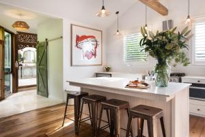 uma cozinha com uma grande ilha branca com bancos em Stockton House em Daylesford