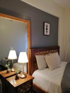碧瑤的住宿－The Cloudbaguio Bristle Ridge，一间卧室配有一张床和一张桌子上的两盏灯。