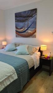 a bedroom with a bed and a painting on the wall at Coorong Lakeside Cottage in Meningie