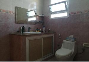 Muscat Homestay & Hospitality في مسقط: حمام مع مرحاض ومغسلة ومرآة