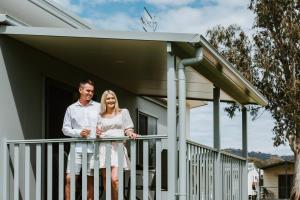 a man and woman standing on a balcony of a house at Mudgee Valley Park in Mudgee