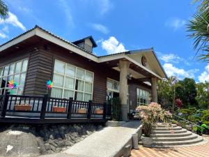 ein Holzhaus mit einer Veranda und ein paar Blumen in der Unterkunft Hoya Spa Hotel in Ruisui