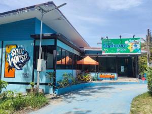 een blauw gebouw met een bord ervoor bij Seahorse Lipe Hostel in Ko Lipe