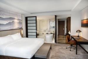 a bedroom with a bed and a desk and a bathroom at Crowne Plaza Vinh Yen City Centre by IHG in Yen