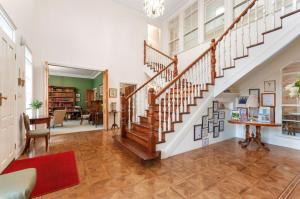 een trap in een woonkamer met een rood tapijt bij Montfort Manor in Traralgon