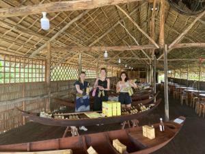 three women standing in a boat in a building at Green Sunshine Homestay in Can Tho