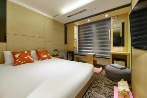 pokój hotelowy z łóżkiem i telewizorem w obiekcie JEJU Western Grace Hotel w mieście Seogwipo