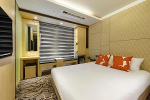 sypialnia z białym łóżkiem i oknem w obiekcie JEJU Western Grace Hotel w mieście Seogwipo