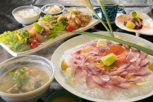 a table with plates of food and bowls of soup at Nagahigawa in Miyazaki