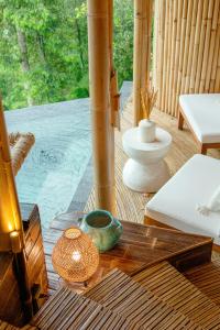 - une table en bois avec un vase au-dessus d'une terrasse couverte dans l'établissement Cliffside Bamboo Treehouse with Pool and View, à Bungbungan