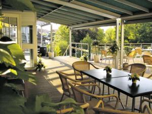 eine Terrasse mit Tischen und Stühlen auf einer Terrasse in der Unterkunft Hotel Højslev Kro in Højslev