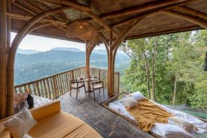 Bungbungan的住宿－Cliffside Bamboo Treehouse with Pool and View，一间设有床铺和一张桌子的房间