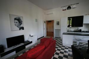 ein Wohnzimmer mit einem roten Sofa und einer Küche in der Unterkunft Irene's Home The Residence in Rom
