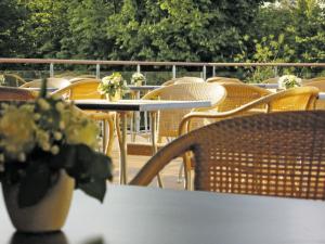 Une bande de tables et de chaises avec des fleurs sur elles dans l'établissement Hotel Højslev Kro, à Højslev