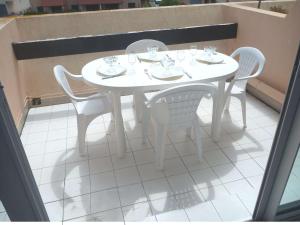 マルセイヤンにあるAppartement Marseillan-Plage, 2 pièces, 4 personnes - FR-1-387-67の白いテーブルと椅子が備わるパティオ