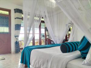 a bedroom with a white bed with a canopy at Royal Vantage in Ella