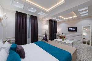 a hotel room with a large bed and a television at Zarafshon Parkside in Samarkand