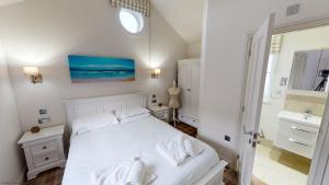 a white bedroom with a bed and a bathroom at Blue Anchor Retreat at The Bay Filey, sleeps 4, 2 dogs welcome for free too in Filey +19 photos