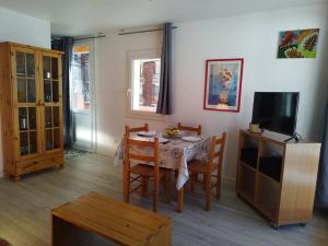 un salon avec une table à manger et une télévision dans l'établissement Maxi Studio à Orcières : 4 pers, proche des pistes, lumineux avec 2 balcons & Wi-Fi - FR-1-262-99, à Forest des Baniols
